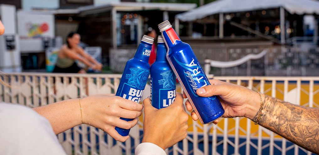 Friends toasting Bud Light and Michelob Ultra beers on the outdoor patio at Ferg's Sports Bar St Pete